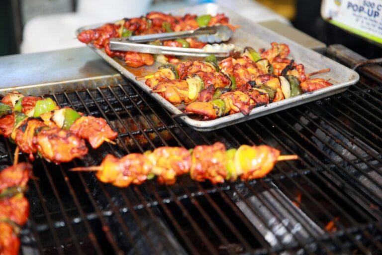 Caribbean-style jerk chicken grilling with peppers and onions