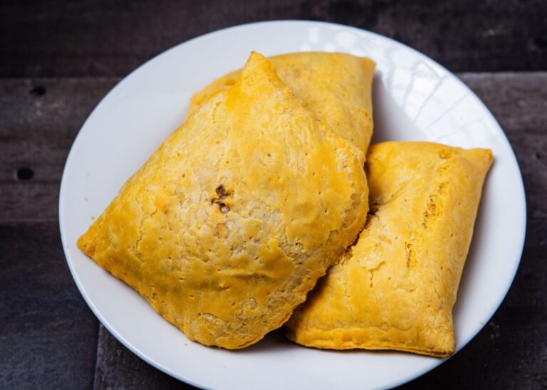 Golden Jamaican beef patties served on a white plate